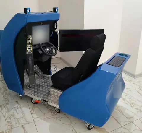 Psikoteknik simülatörünün yandan görünümü: direksiyon, pedallar, sürücü koltuğu ve test ekranı
